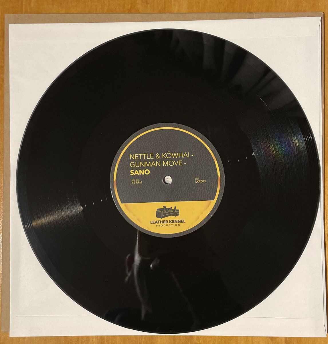 A photo of a vinyl record, with 'Nettle & Kōwhai - Gunman Move - Sano' printed in the centre
