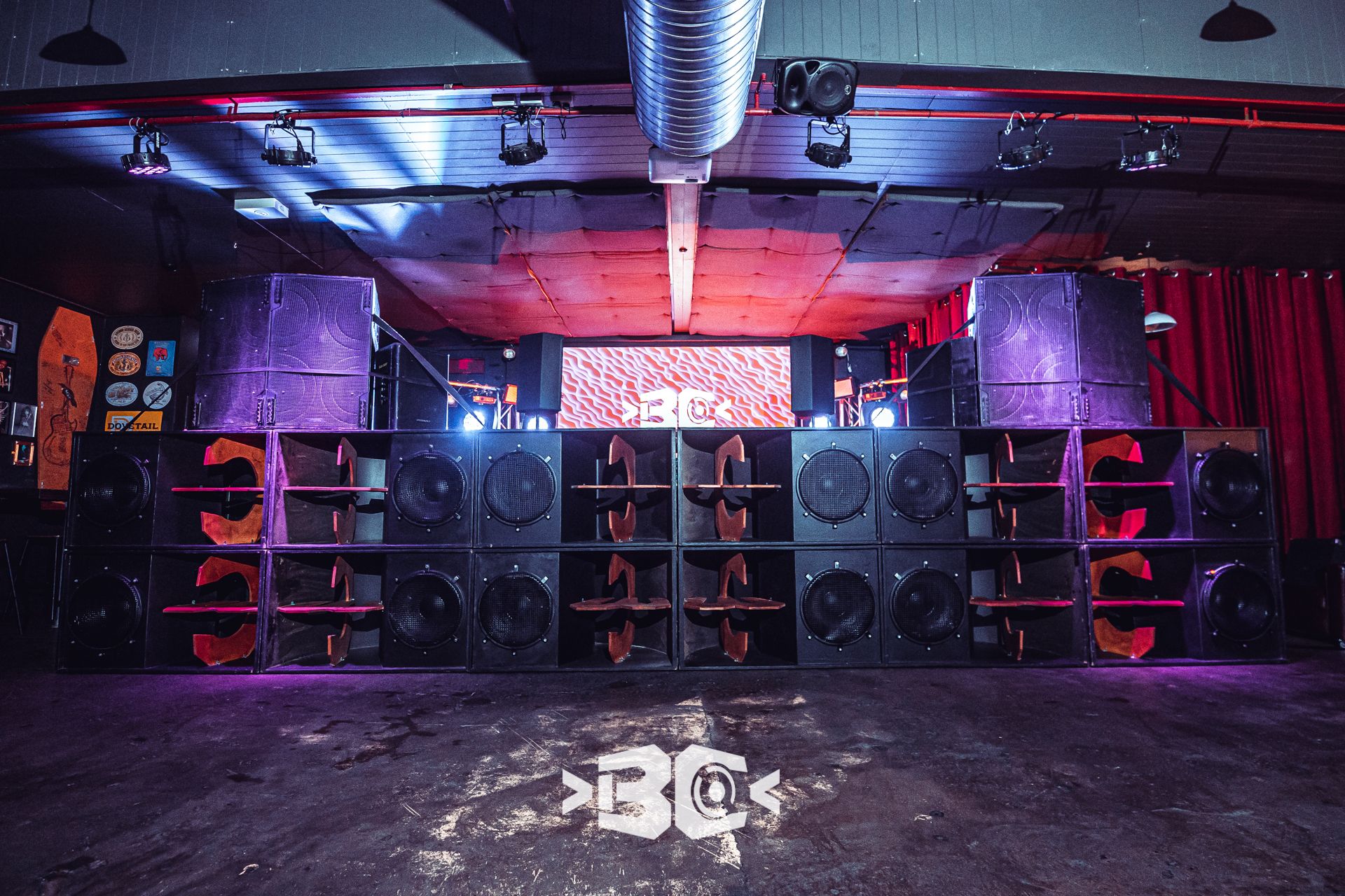 A huge rig, lit in purple and red, in an indoor venue