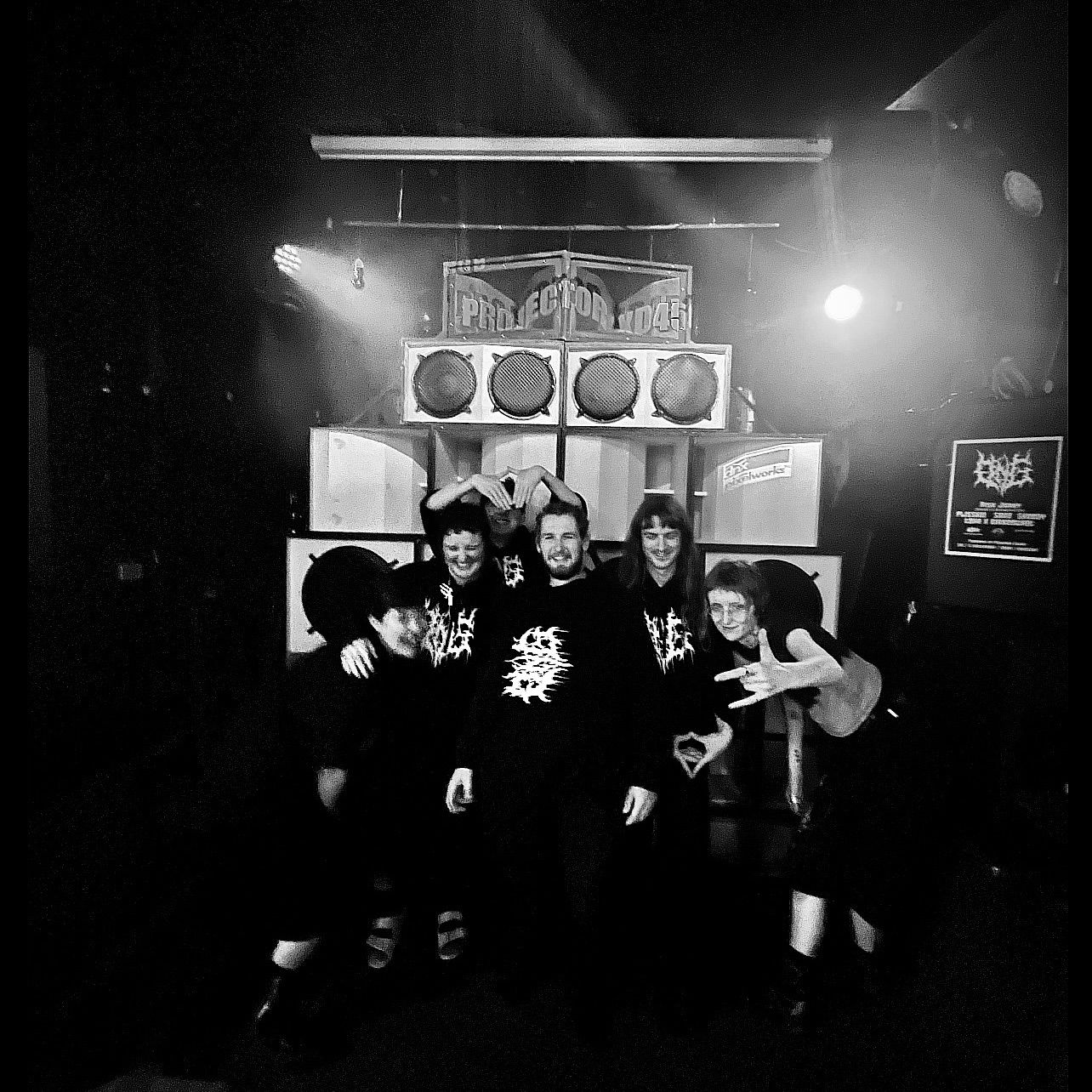 A black and white shot of the crew of six or so people, all in DNG hoodies, in front of a dope soundsystem