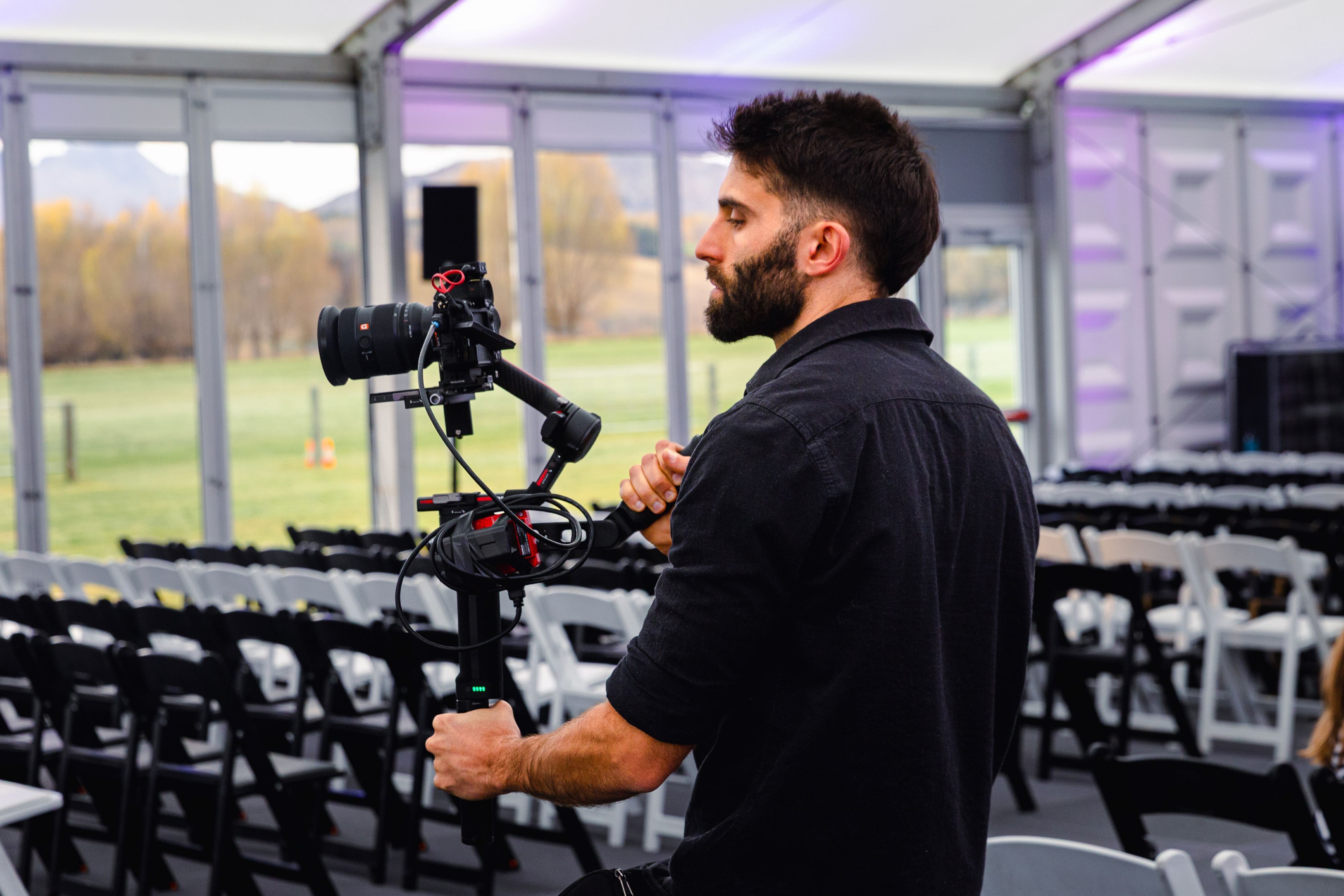 A side-on shot Federico mid-shoot, holding a camera rig in front of him