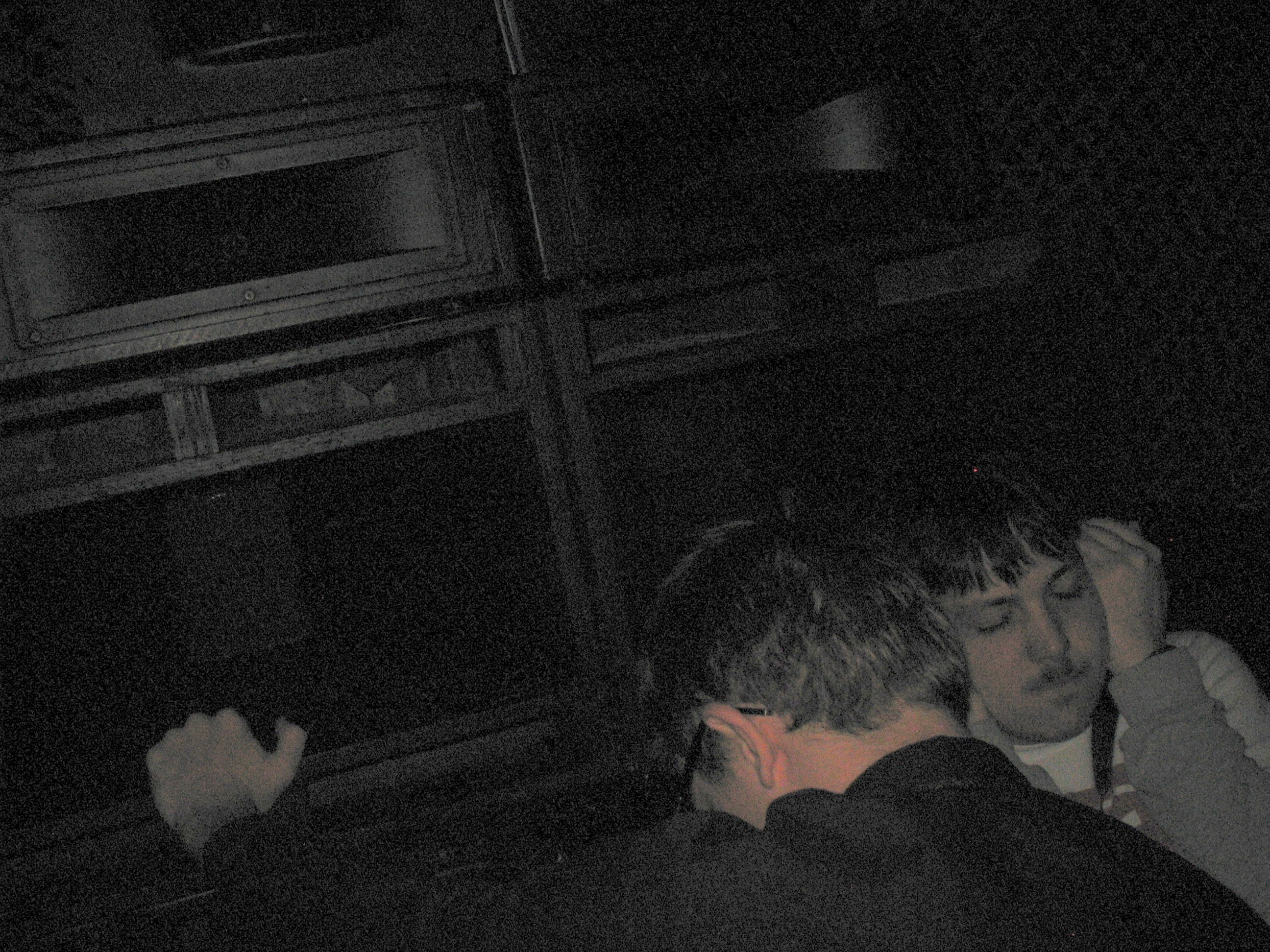 A close-up of a couple of people lost in the music right in front of a speaker stack