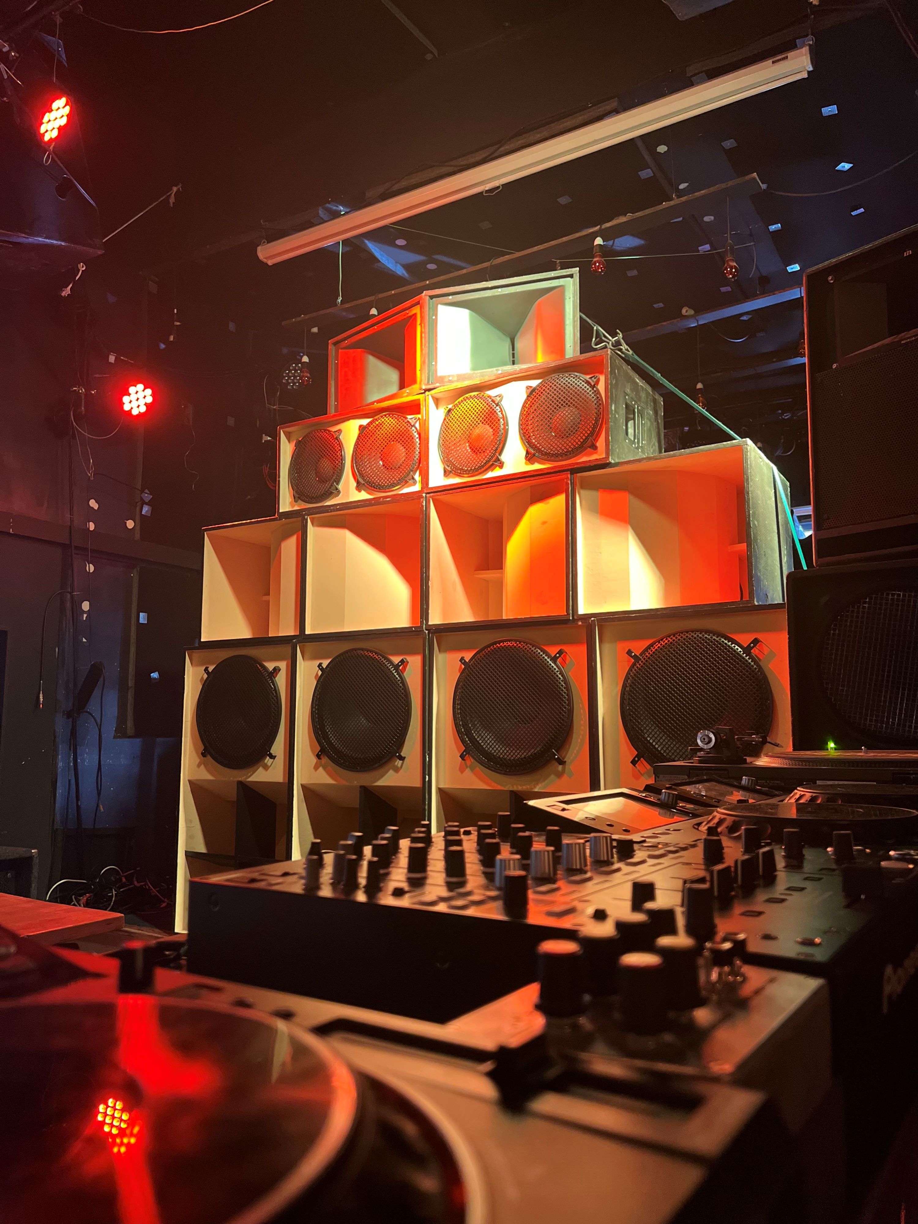 A towering soundsystem, lit up with warm lighting