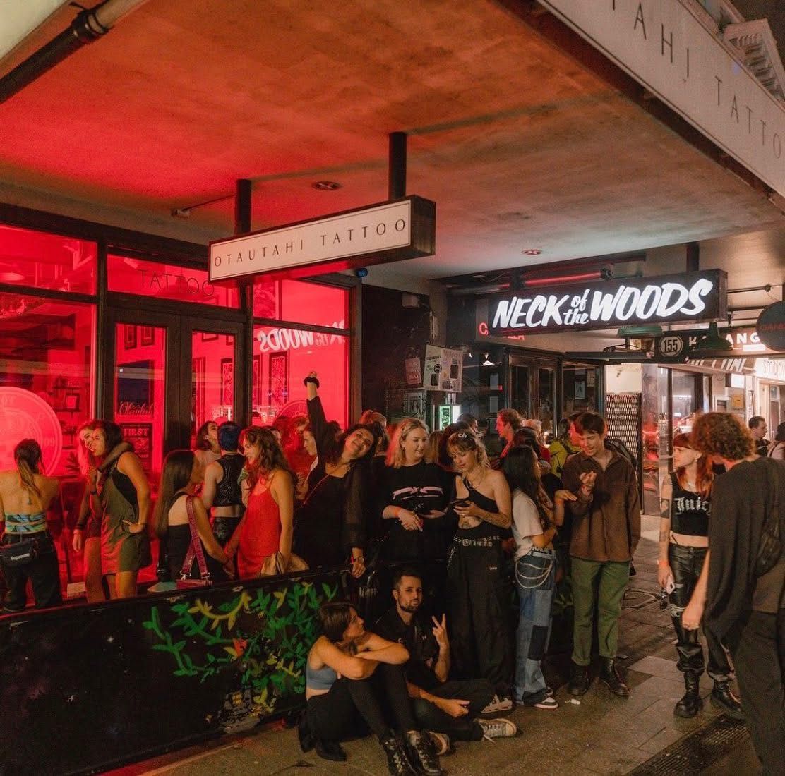 The street front of neck of the woods, with people standing and sitting