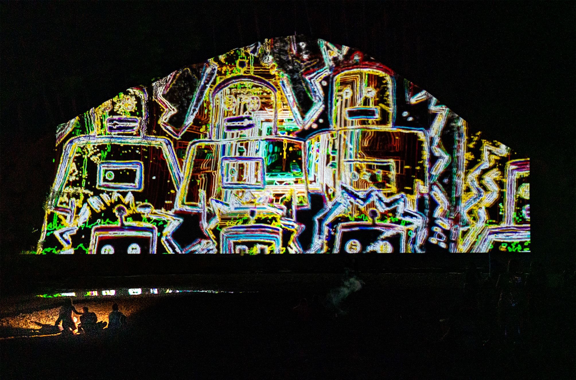 A busy projection of wiry robots on the side of a large building, it is multicoloured and fascinating